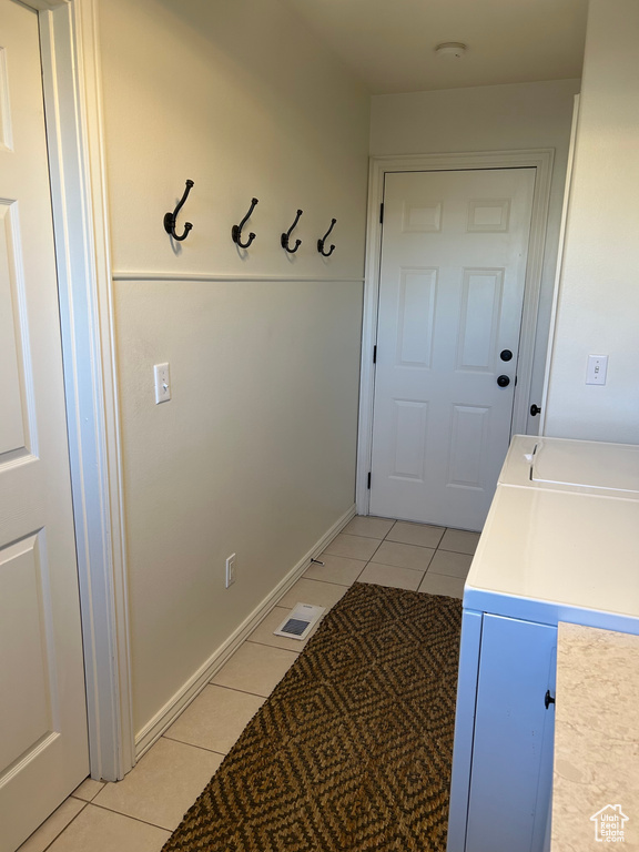 Interior space featuring light tile patterned floors and washing machine and clothes dryer