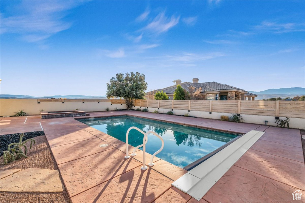 View of swimming pool with a mountain view and a patio area