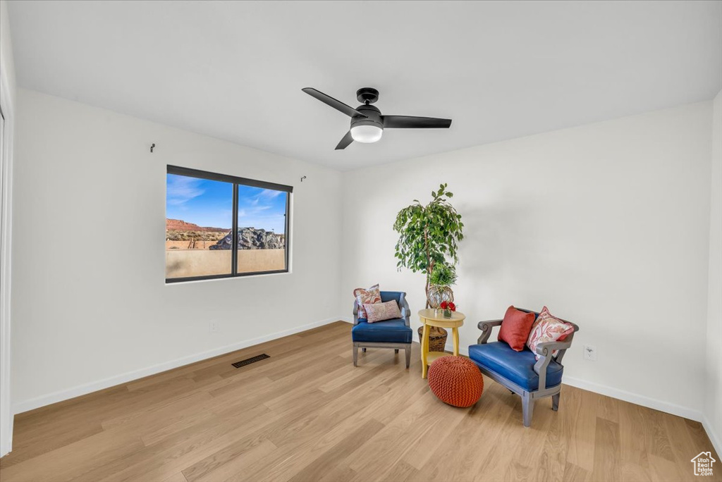 Living area with ceiling fan and light hardwood / wood-style floors