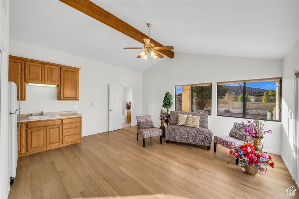 Living area featuring beam ceiling, ceiling fan, sink, light hardwood / wood-style flooring, and high vaulted ceiling
