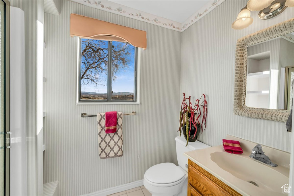 Bathroom featuring toilet, vanity, and tile patterned floors