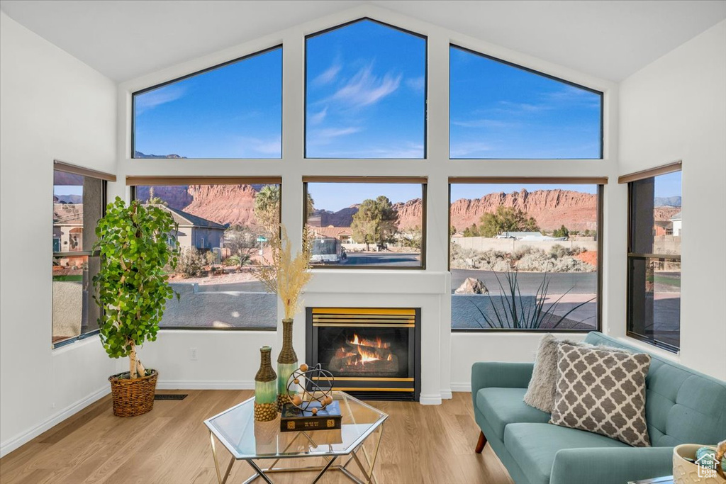Living room with a mountain view, wood-type flooring, and vaulted ceiling