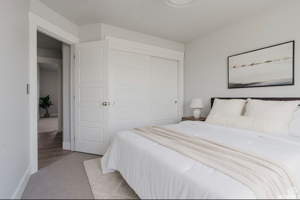 Bedroom featuring light carpet and a closet