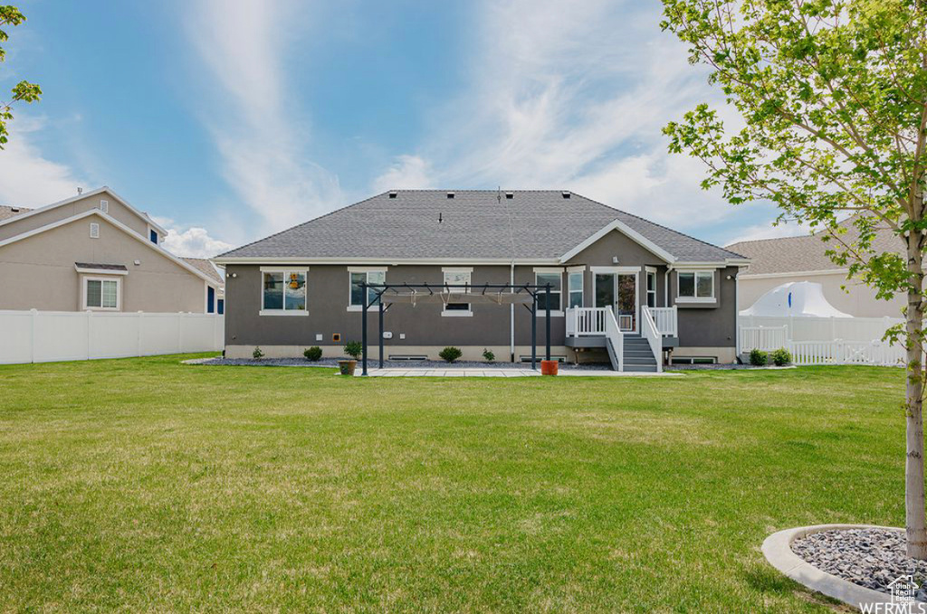 Back of property with a lawn and a pergola