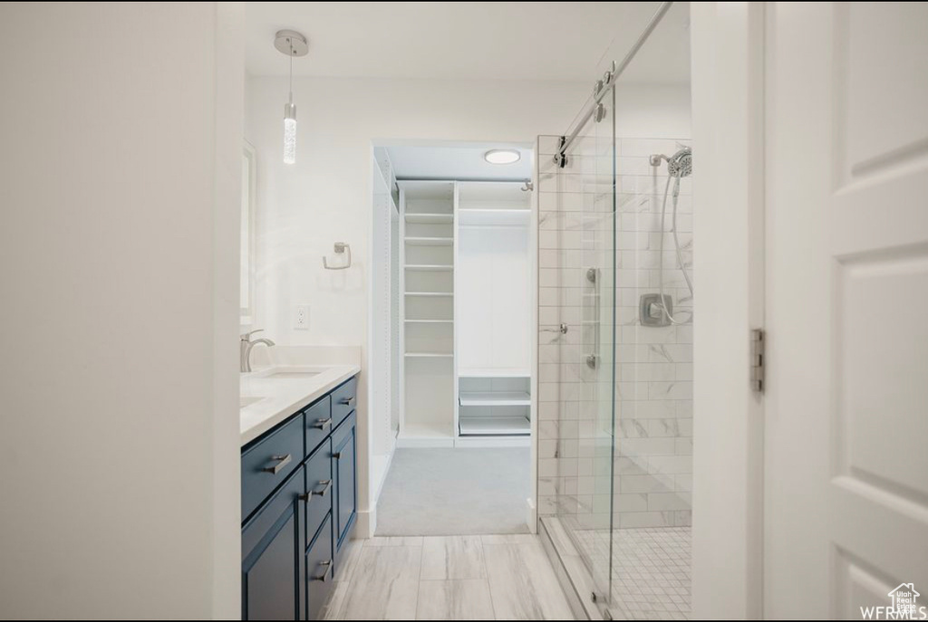 Bathroom featuring vanity and a shower with door
