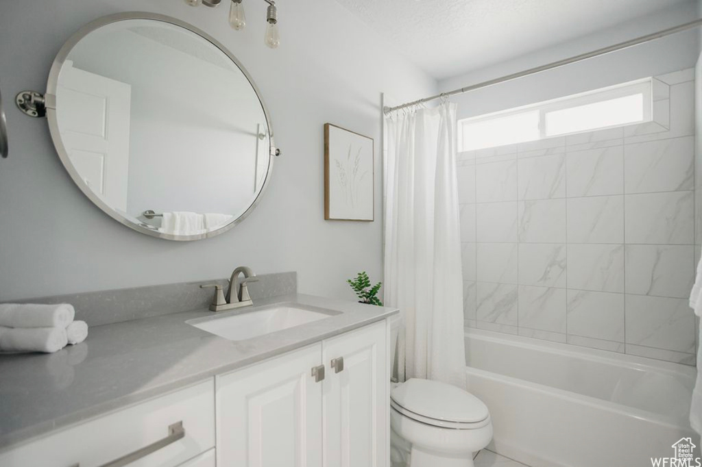 Full bathroom featuring shower / bath combo, toilet, and vanity