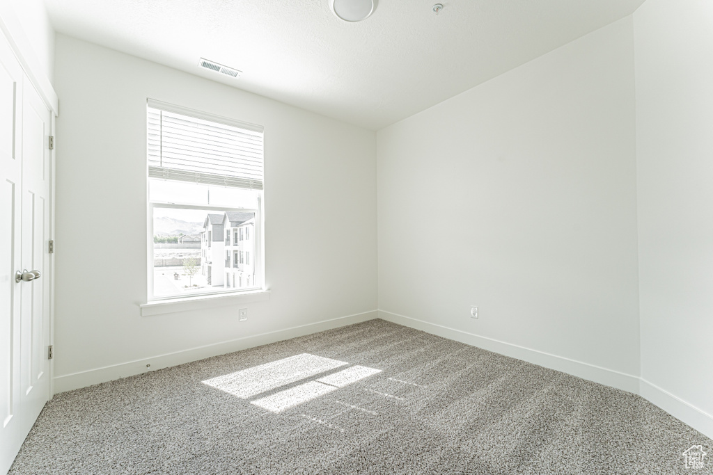 Carpeted spare room with baseboards