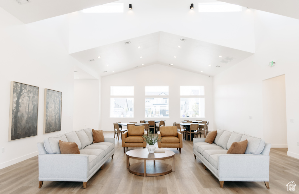 Living room featuring high vaulted ceiling and light hardwood / wood-style floors