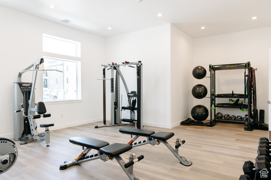 Exercise area with light hardwood / wood-style floors