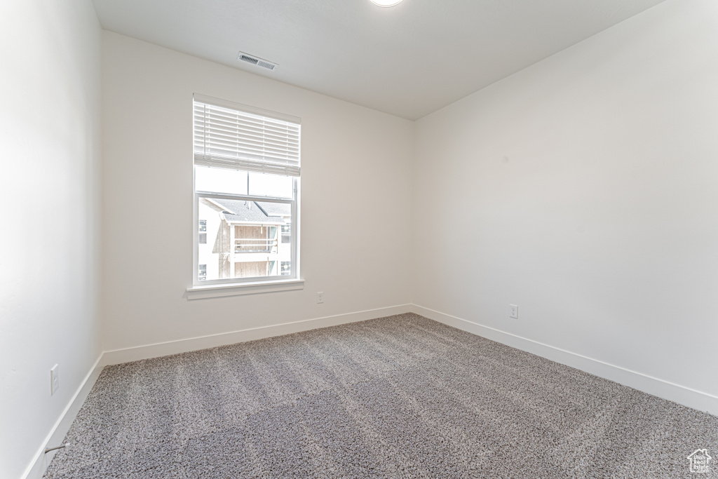 Carpeted spare room with baseboards