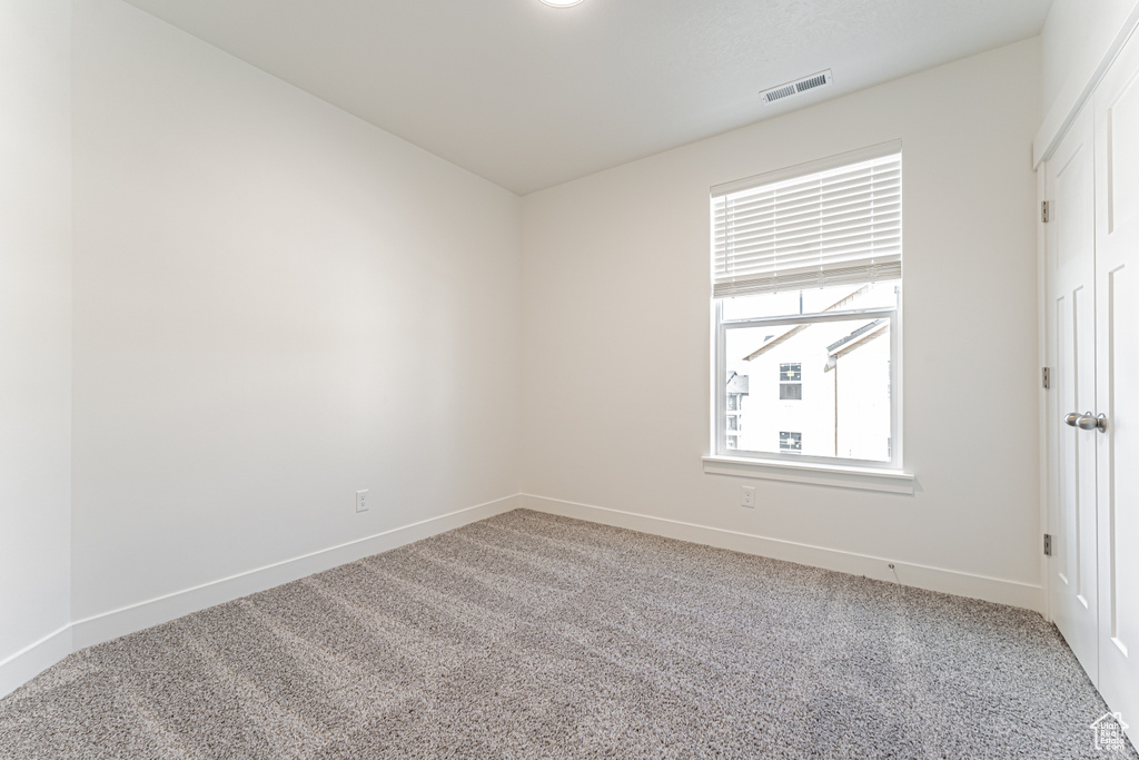 Empty room with light carpet and baseboards