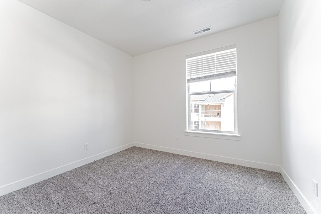 Carpeted empty room with baseboards