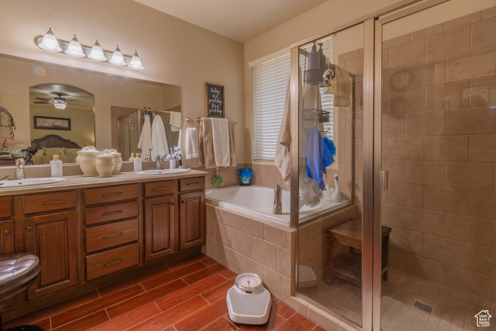 Bathroom featuring ceiling fan, independent shower and bath, and vanity