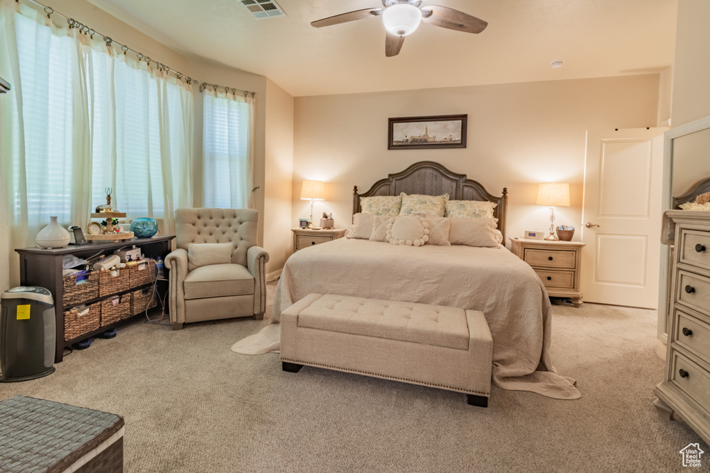 Carpeted bedroom featuring ceiling fan