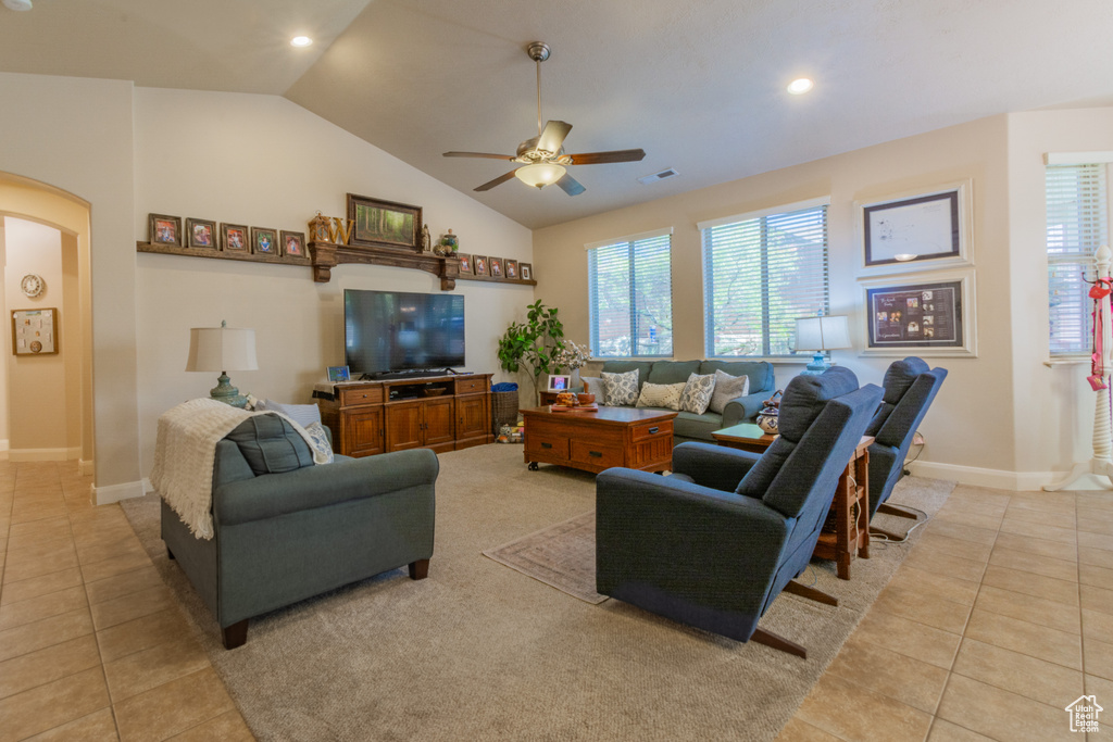 Tiled living room with ceiling fan and vaulted ceiling