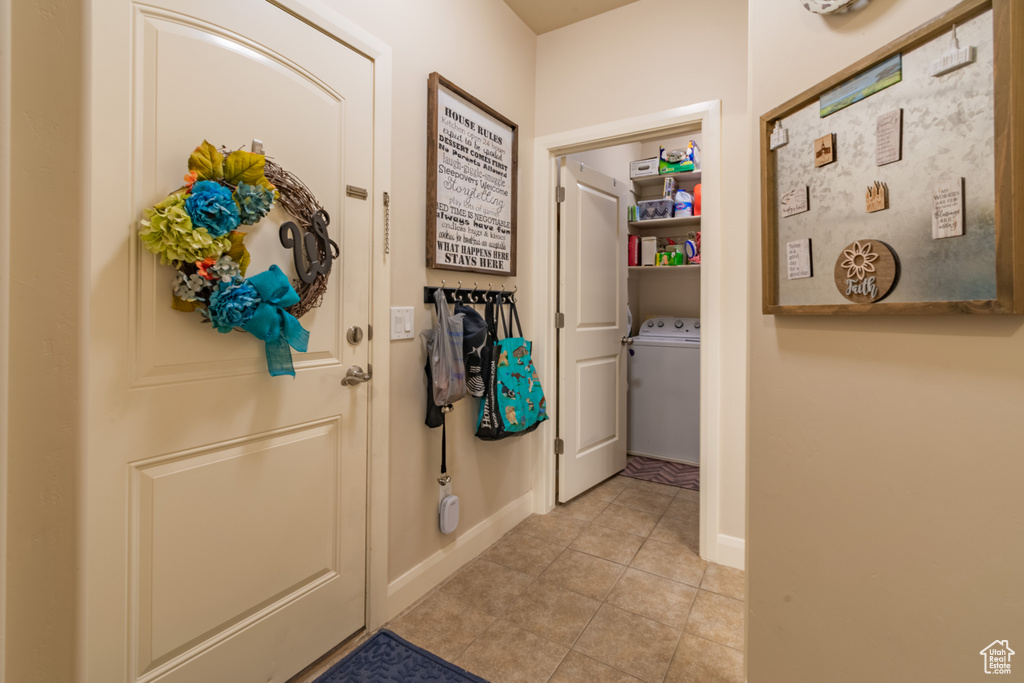 Doorway to outside featuring light tile patterned floors and washer / clothes dryer