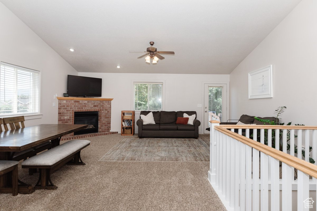 Living room with plenty of natural light, lofted ceiling, and light colored carpet