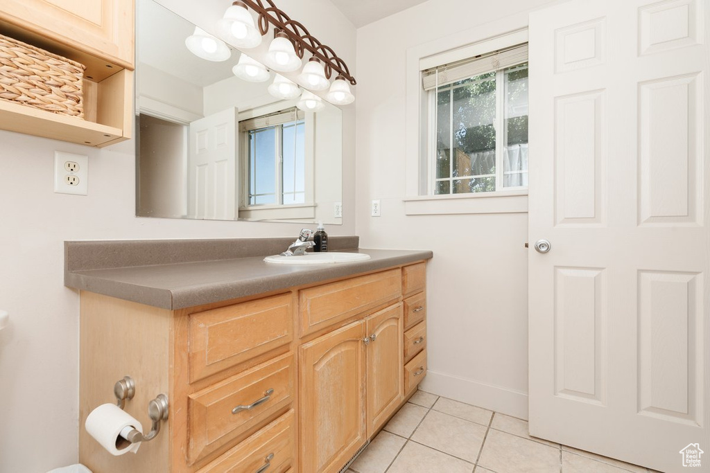 Bathroom featuring tile patterned flooring, a wealth of natural light, and vanity