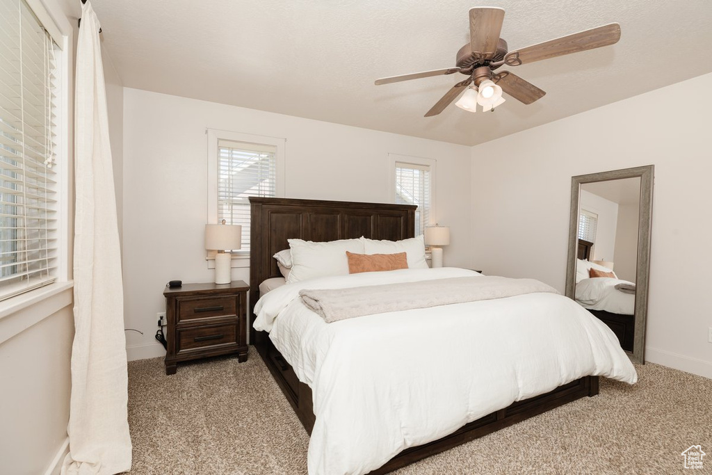 Carpeted bedroom featuring ceiling fan