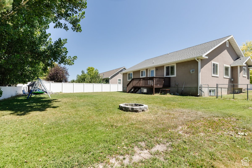 View of yard with a deck and a fire pit