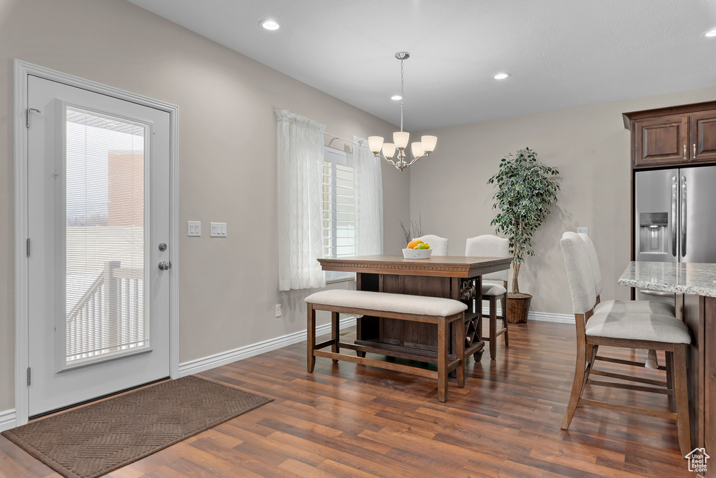 Dining area featuring plenty of natural light, dark hardwood / wood-style floors, and a notable chandelier