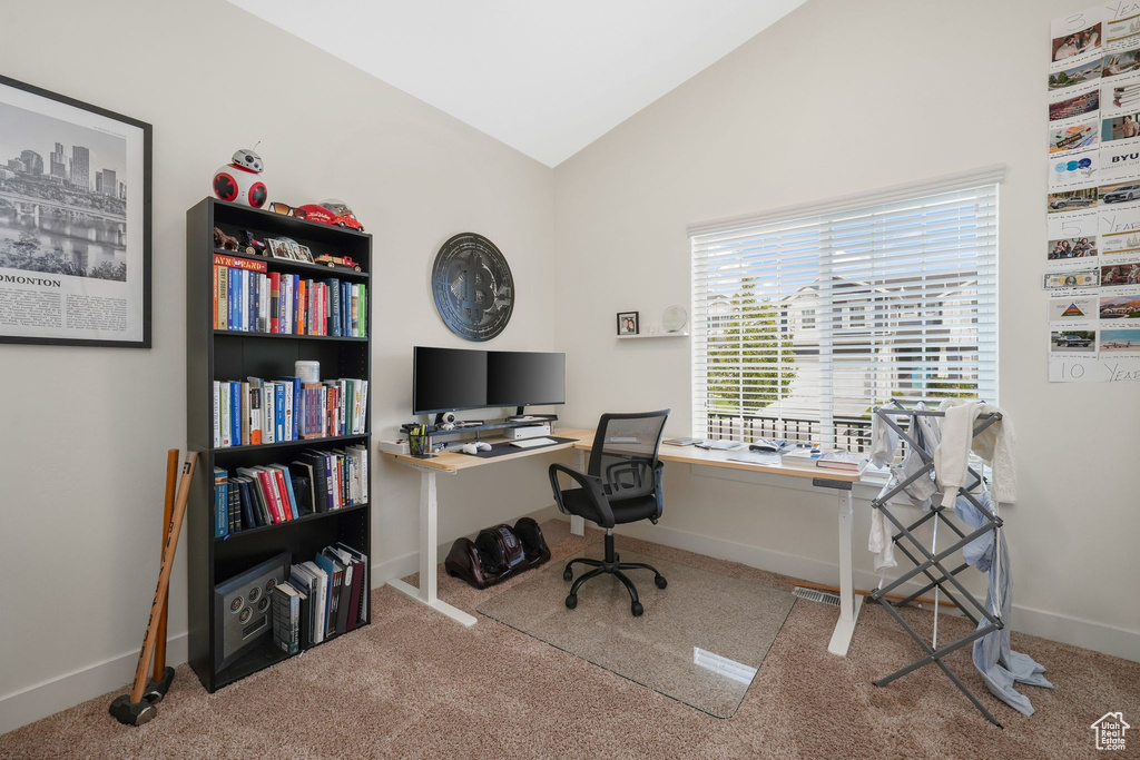 Carpeted home office featuring lofted ceiling
