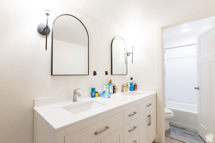 Full bathroom with vanity, shower / bathtub combination, and toilet