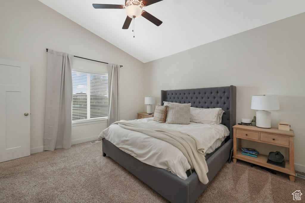 Bedroom featuring carpet, ceiling fan, and vaulted ceiling