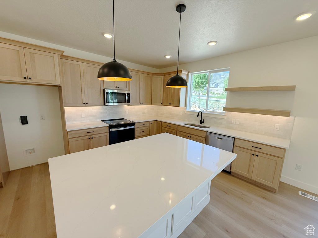 Kitchen featuring stainless steel appliances, open shelves, light brown cabinetry, and recessed lighting