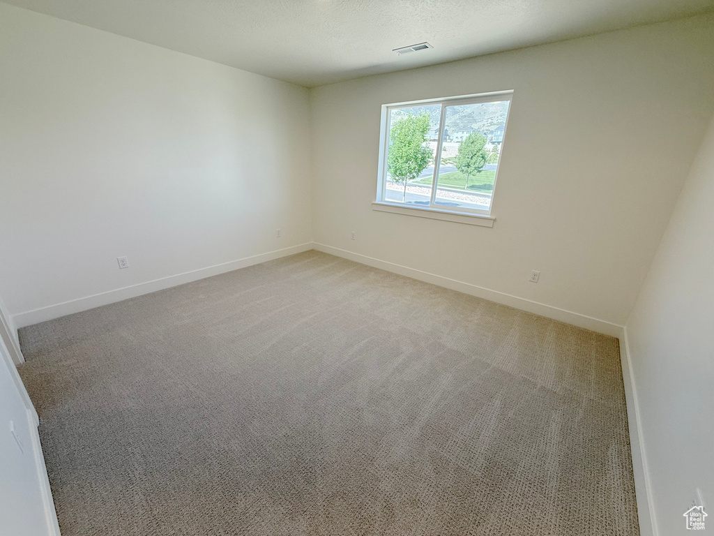 Unfurnished room featuring baseboards and light colored carpet
