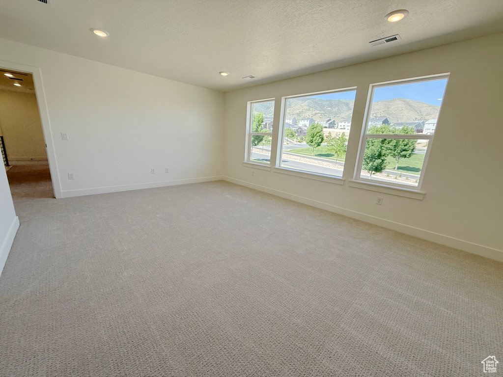 Spare room with light colored carpet, baseboards, and recessed lighting