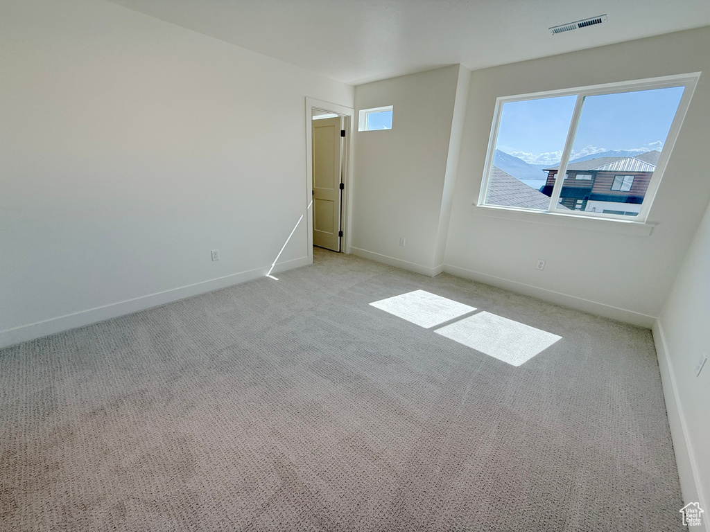 Unfurnished room with light colored carpet and baseboards