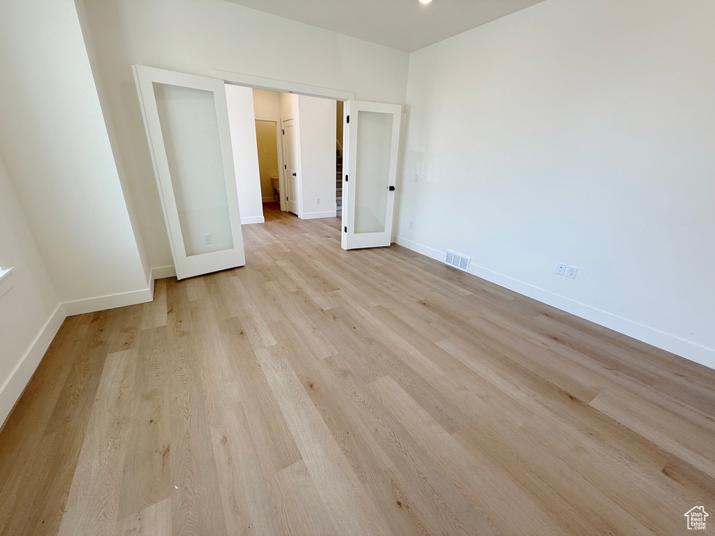 Unfurnished bedroom with light wood-style flooring and baseboards
