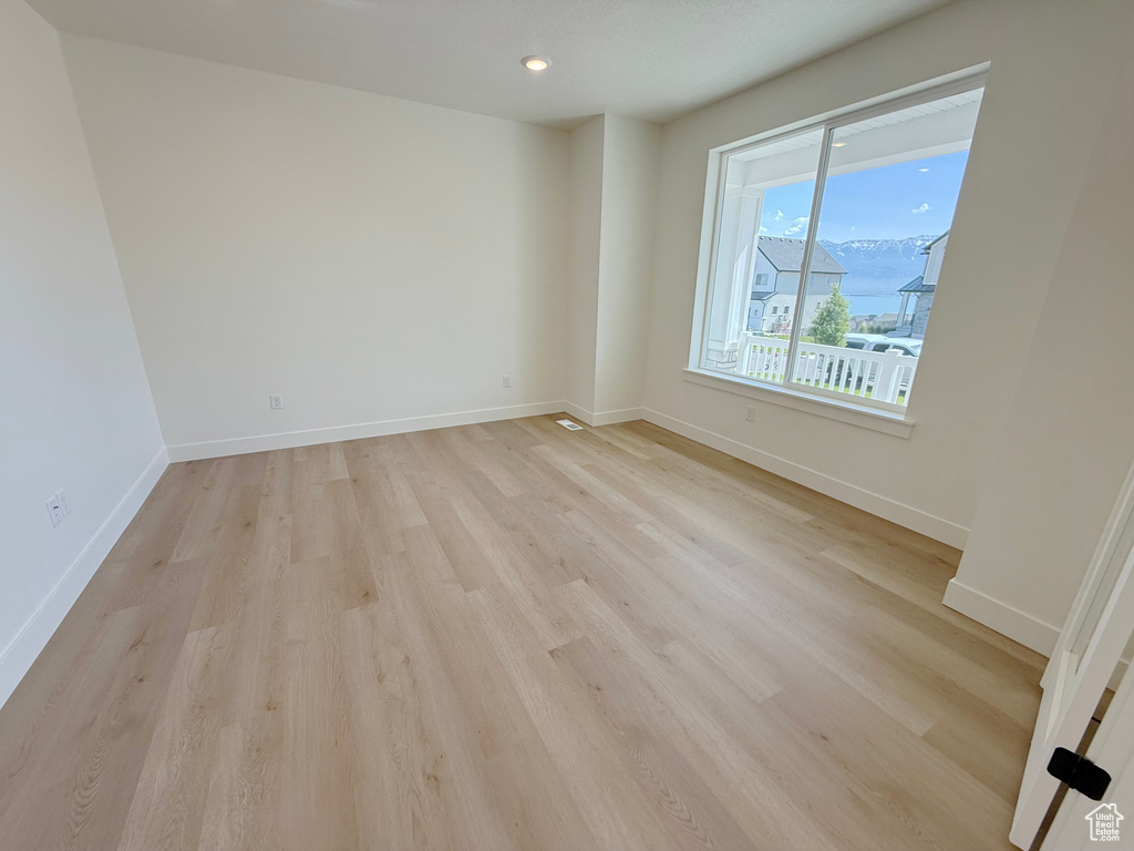 Spare room with light wood-type flooring, baseboards, and recessed lighting