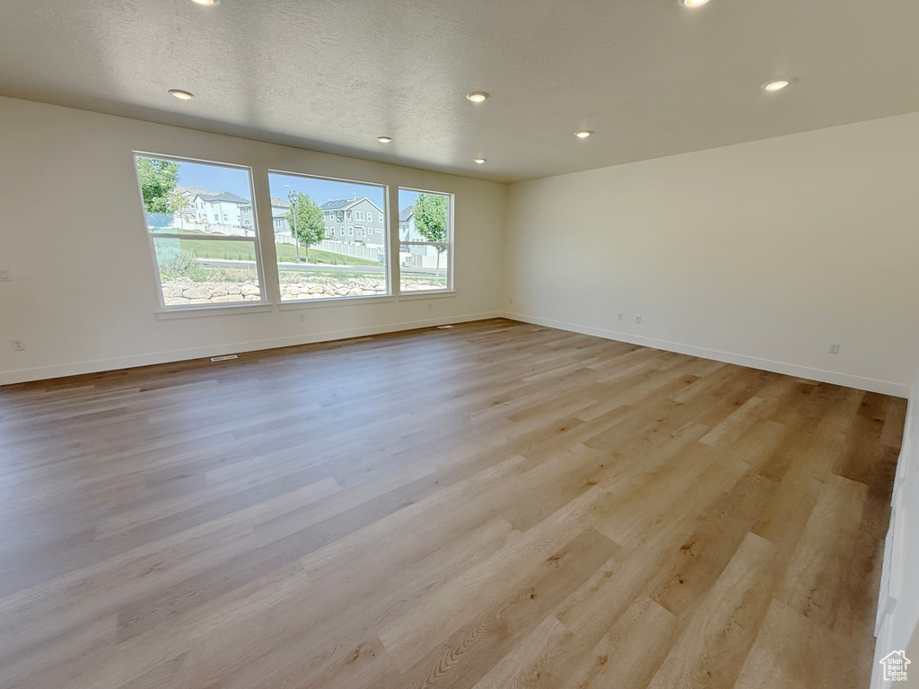 Empty room featuring recessed lighting, baseboards, and light wood-type flooring
