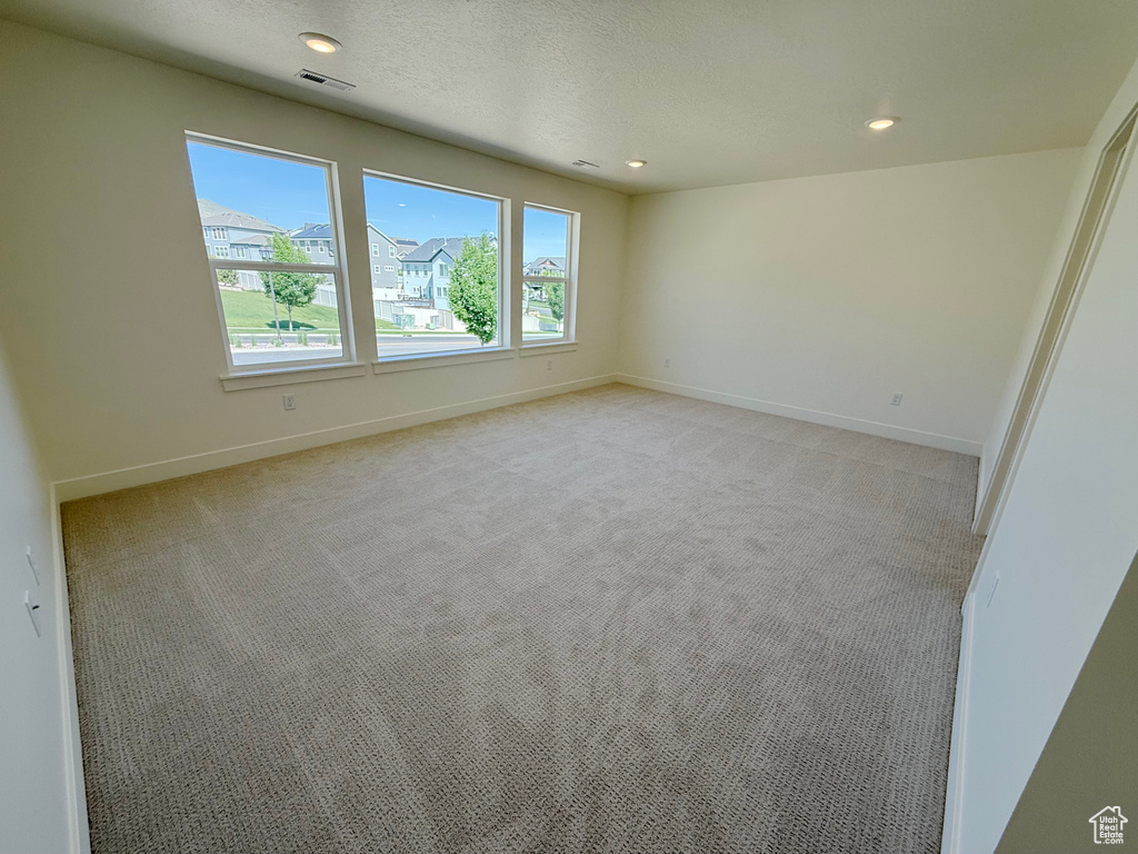 Empty room featuring light carpet, baseboards, and recessed lighting