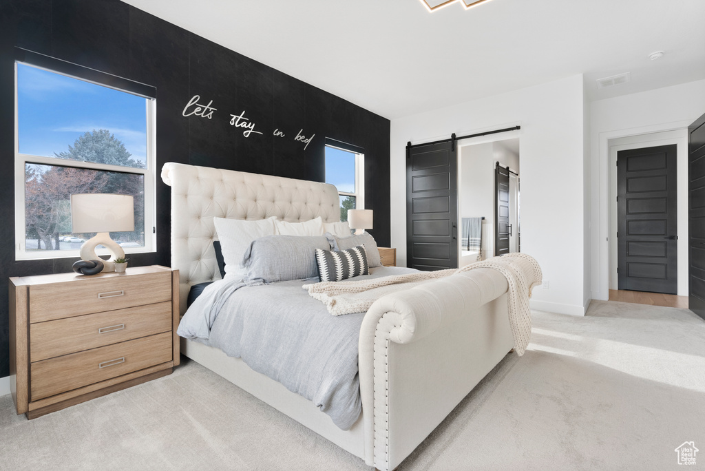 Carpeted bedroom featuring a barn door