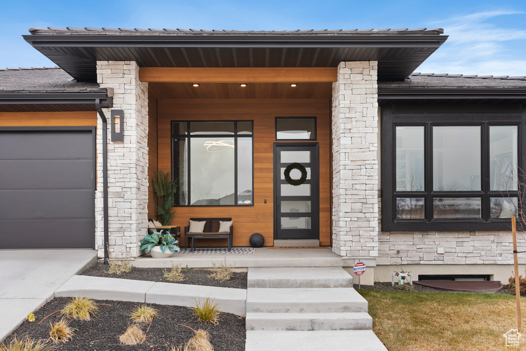 Entrance to property featuring a porch and a garage