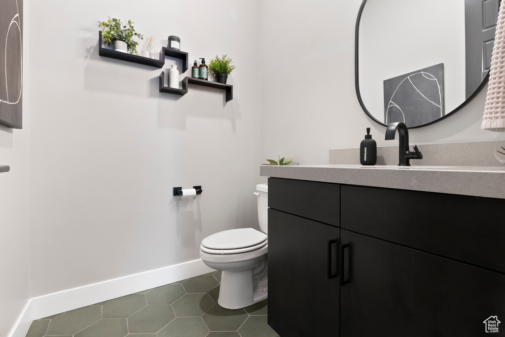 Bathroom with tile patterned floors, vanity, and toilet