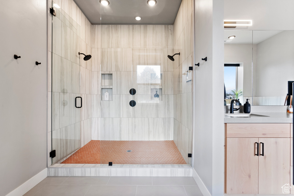 Bathroom with vanity, tile patterned floors, and a shower with door