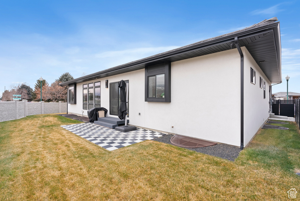 Back of property featuring a yard and a patio