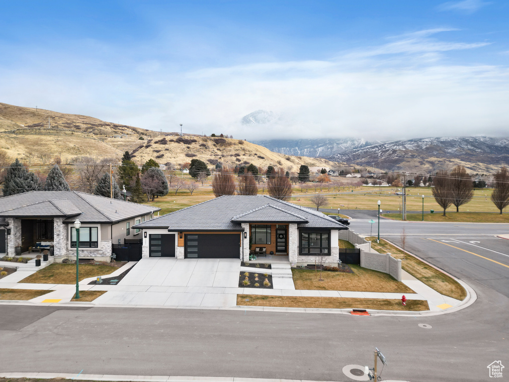 View of front of property with a mountain view, a porch, and a garage