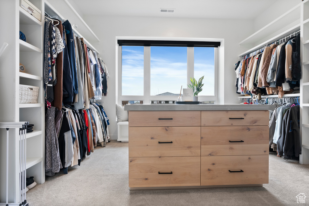 Walk in closet with light carpet