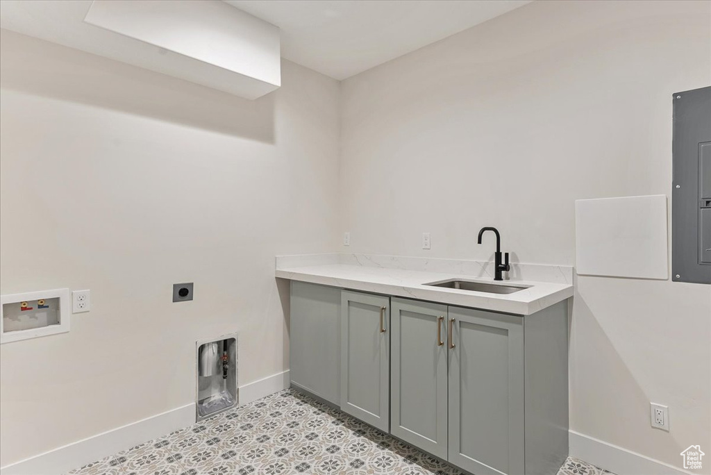 Clothes washing area featuring hookup for an electric dryer, cabinets, sink, and hookup for a washing machine