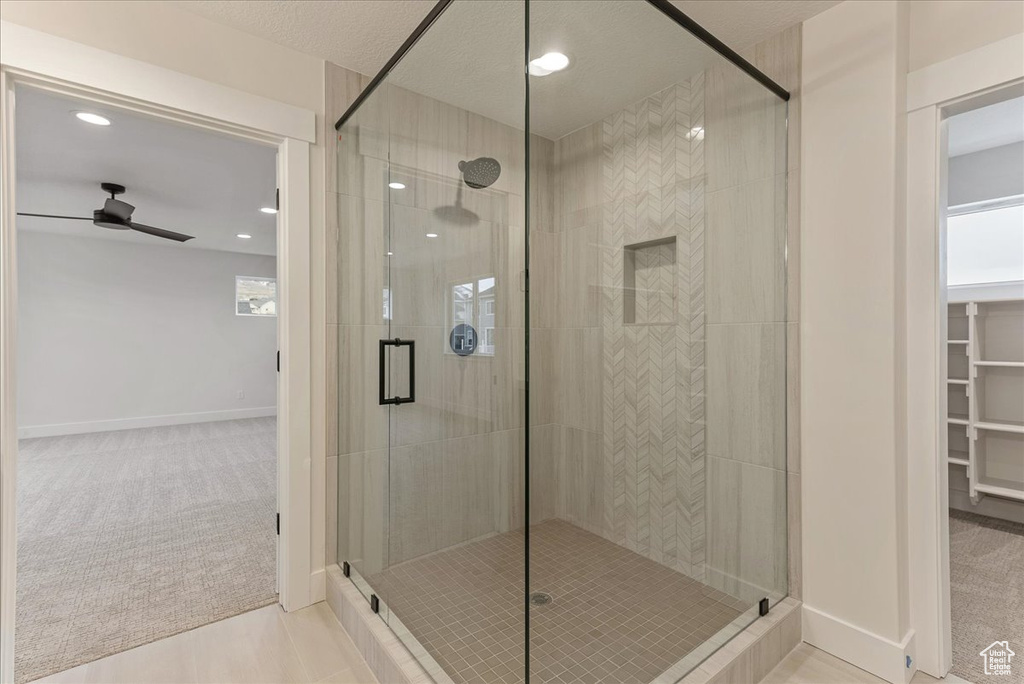 Bathroom with an enclosed shower, a textured ceiling, tile patterned flooring, and ceiling fan