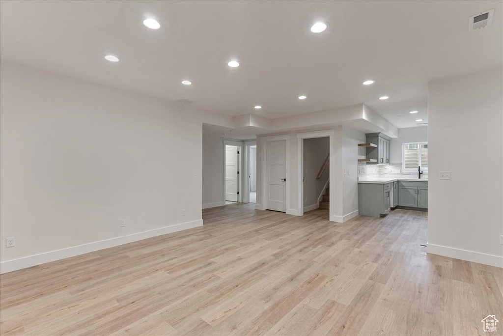 Unfurnished living room with sink and light hardwood / wood-style flooring