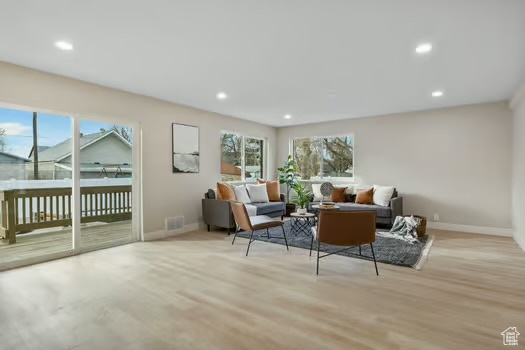 Living room with plenty of natural light and light hardwood / wood-style floors