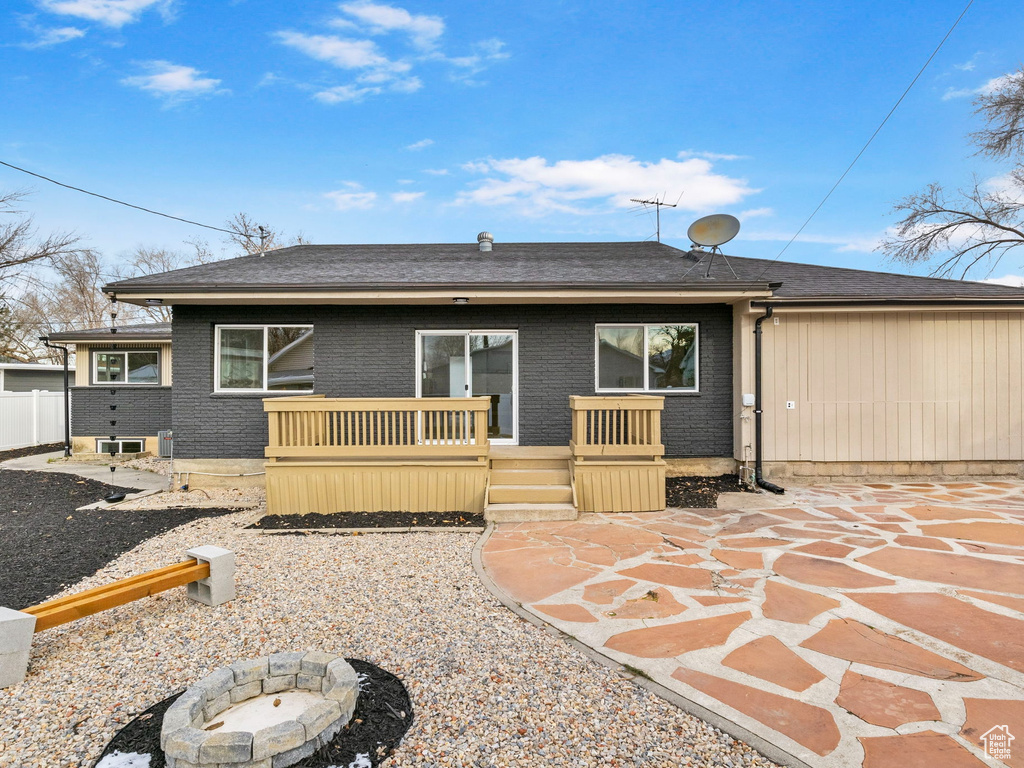 Back of house with a fire pit and a patio area