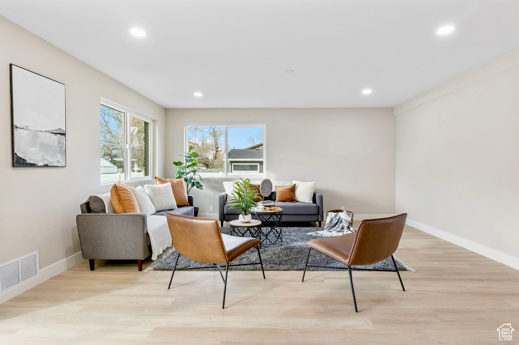 Living room with recessed lighting, visible vents, and light wood-style floors