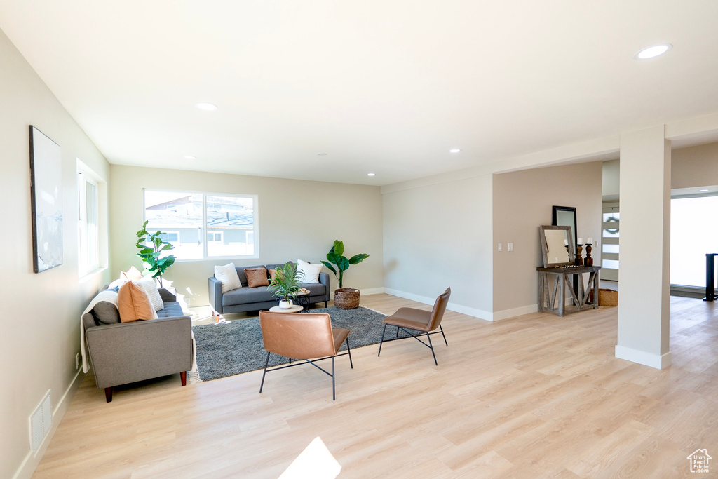 Living room with baseboards, light wood-style flooring, visible vents, and recessed lighting